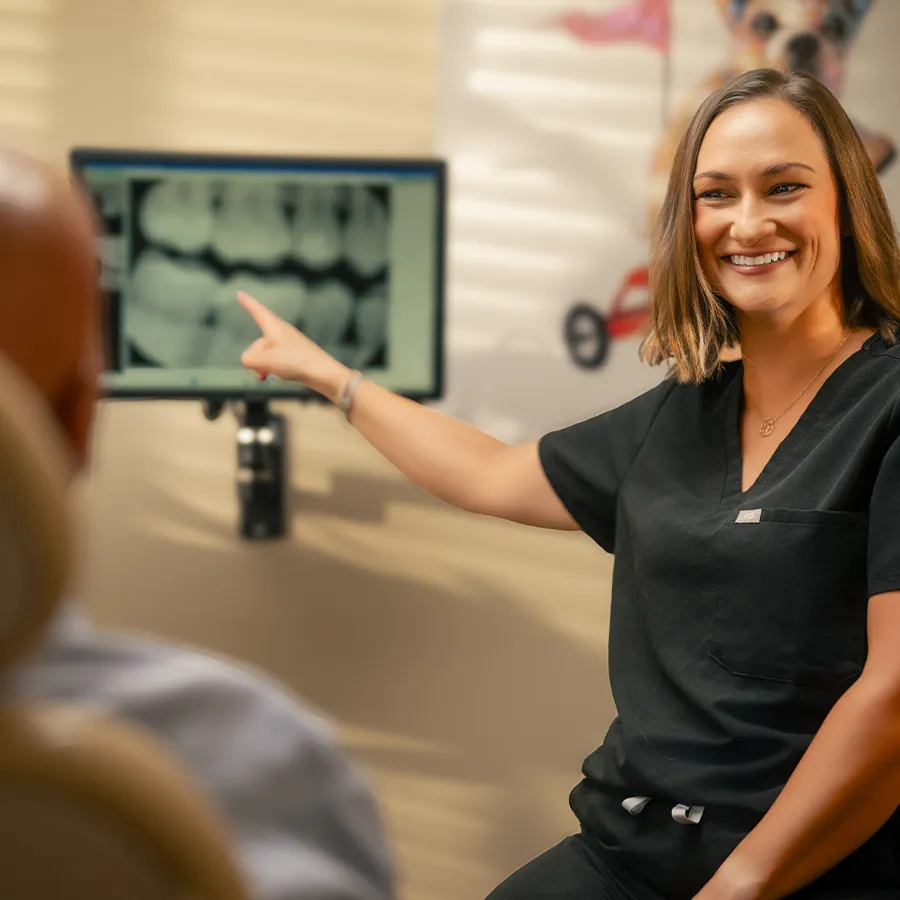 natural-looking-crowns-consultation-bonita-springs Dental team member reviewing X-rays with a patient during a crown consultation in Bonita Springs.